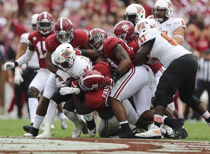 Alabama defenders Isaiah Buggs (49), Joshua Frazier (69) and Anfernee Jennings (33) bring down Mercer running back Tee Mitchell during Saturday's 56-0 win by the Crimson Tide. (Kent Gidley/Alabama Photo)