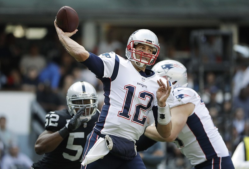 New England Patriots quarterback Tom Brady (12) passes under