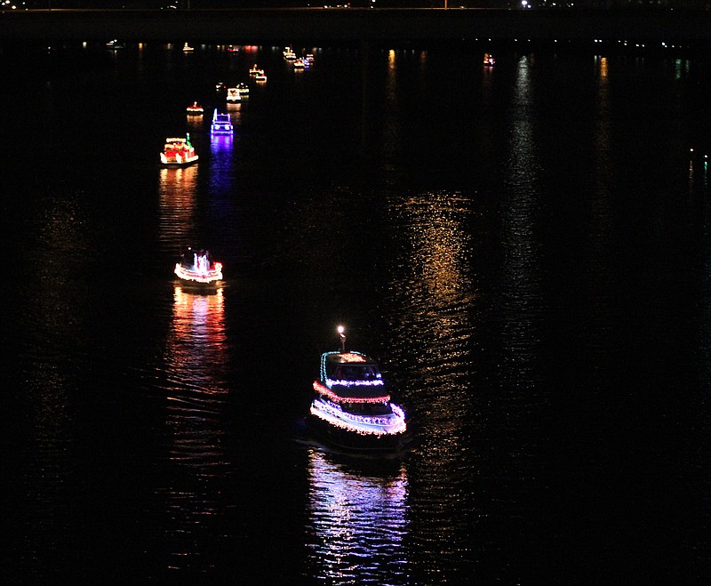 Boats prepare to pass under the Walnut Street Bridge in a previous lighted boat parade at Ross's Landing. (Staff File Photo)