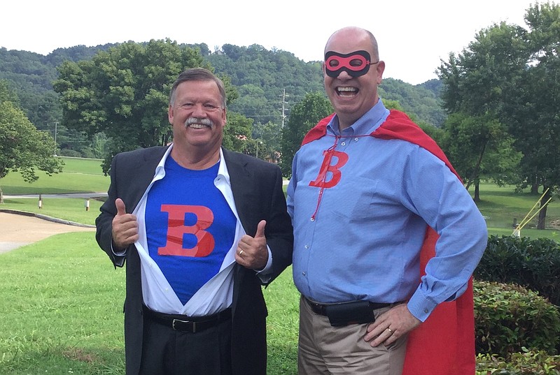 Hamilton County Mayor Jim Coppinger, left, and Bethel Bible Village President and CEO Kevin Beirne encourage others to "be a hero" and support the nonprofit child services center. If the center raises $17,000 by Nov. 28, Coppinger has agreed to trade his cape and mask for goggles as the children of Bethel "slime" him. (Contributed photo)