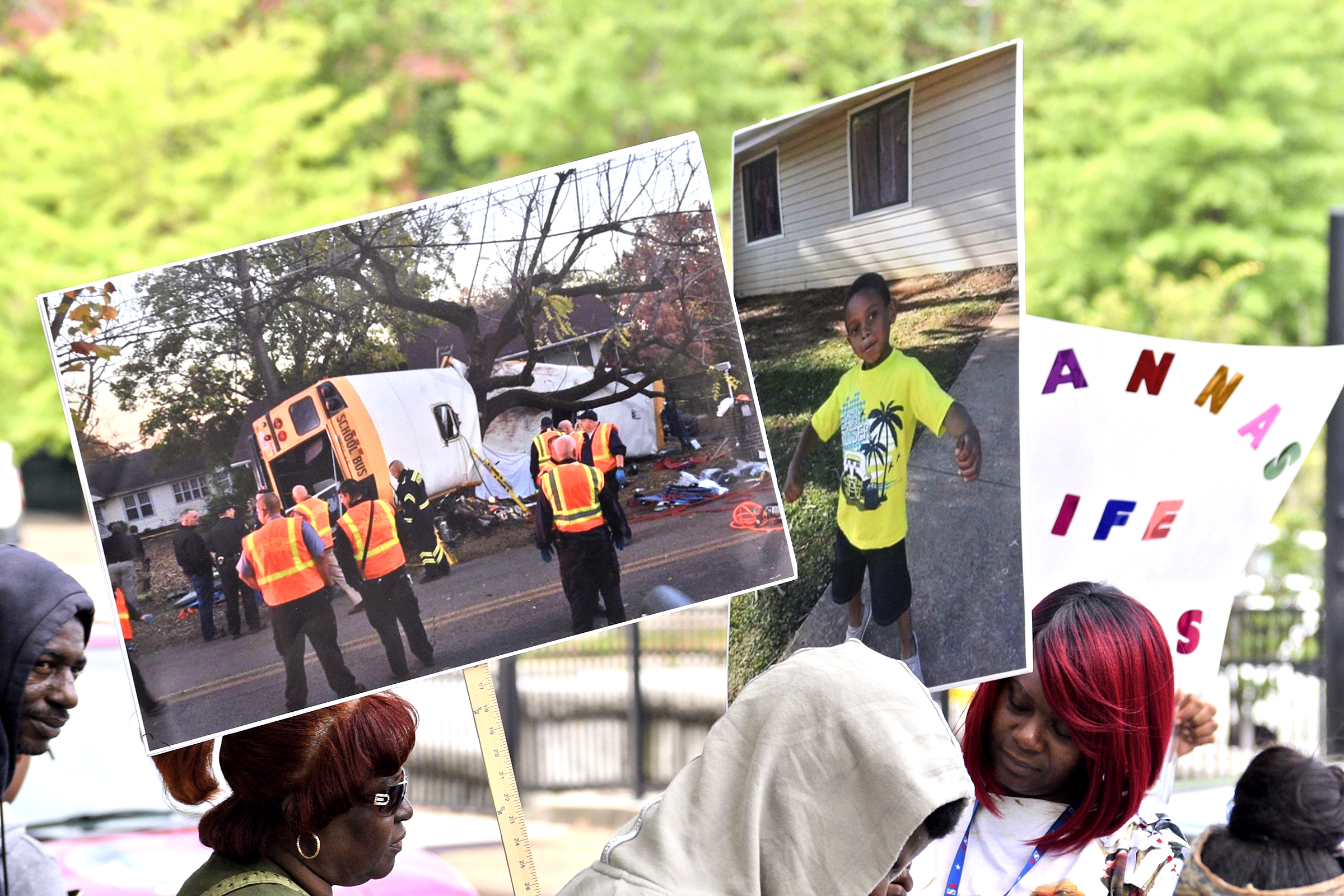 An image of the Woodmore bush crash and one of it's victims adorn signs as people wait to march. A march was held downtownon May 25, 2017 to remember the victims of the Woodmore Bus Crash and draw attention to Durham Transportation being retained as the contractor for the county's buses.