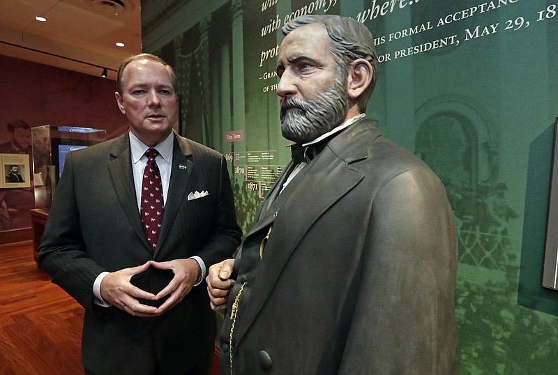 In this Thursday, Nov. 2, 2017 photo, Mississippi State University president Mark Keenum, stands next to a life sized statue of then President Ulysses S. Grant, one of the exhibits in the new presidential museum that is part of the Ulysses S. Grant Presidential Library in the Mitchell Memorial Library in Starkville, Miss. Mississippi State University will launch the new library and exhibit space housing Grant's papers and artifacts on Nov. 30. (AP Photo/Rogelio V. Solis)