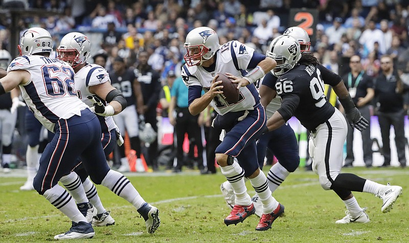 New England Patriots quarterback Tom Brady, center, scrambles against the Oakland Raiders during the first half of an NFL football game Sunday, Nov. 19, 2017, in Mexico City. (AP Photo/Rebecca Blackwell)