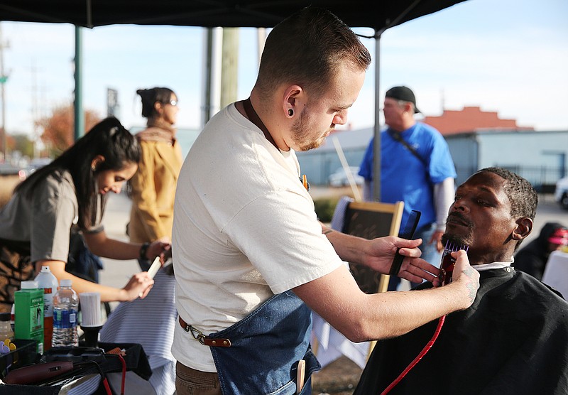 Mitchell Fuqua, a barber at All City Barber Company, trims Tim Green's beard Monday, Nov. 20, 2017, in front of Muse + Metta in Chattanooga, Tenn. The owner Muse + Metta and employees of All City Barber Company got together to give individuals free haircuts across from the Chattanooga Community Kitchen Monday afternoon. All City Barber Company had a couple of employees who volunteered from 1 p.m. until 4 p.m. cutting the hair of about 35 individuals Monday. 