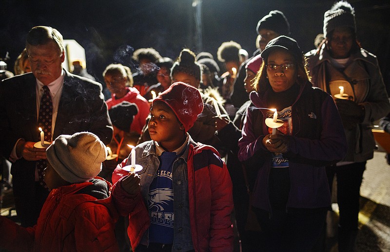 Community members hold candles during a community vigil to remember victims of last year's Hamilton County school bus crash on Talley Road on Tuesday, Nov. 21, 2017, in Chattanooga, Tenn. Parents, friends, and supporters gathered near the spot where one year ago Tuesday, six children from Woodmore Elementary School were killed after bus 366 overturned on the residential street.