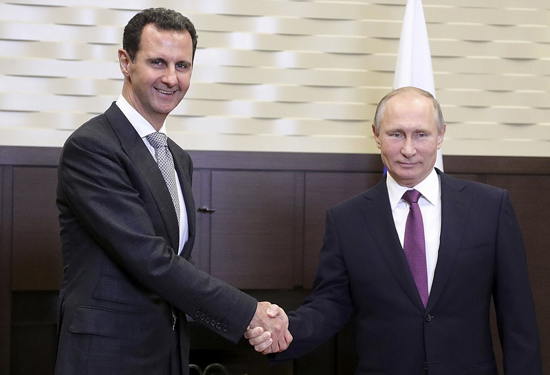 In this photo taken on Monday, Nov. 20, 2017, Russian President Vladimir Putin, right, shakes hand with Syrian President Bashar Assad in the Bocharov Ruchei residence in the Black Sea resort of Sochi, Russia. Russian state TV said the two leaders held bilateral talks on Monday and then met with Russian military chiefs. It was the second time Assad has traveled to Russia to meet with Putin in the course of the country's six-year civil war. (Mikhail Klimentyev, Kremlin Pool Photo via AP)