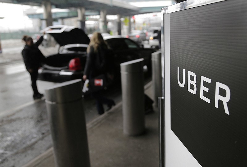 In this March 15, 2017, file photo, a sign marks a pick-up point for the Uber car service at LaGuardia Airport in New York. Uber is coming clean about its cover-up of a year-old hacking attack that stole personal information about more than 57 million of the beleaguered ride-hailing service's customers and drivers. The revelation Tuesday marks the latest stain on Uber's reputation. (AP Photo/Seth Wenig, File)