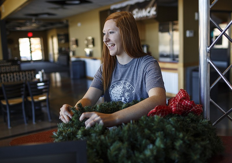 Shelby Duggard straightens a wreathe while decorating for Christmas in her internship at Silverdale Baptist Church on Wednesday, Nov. 22, 2017, in Chattanooga, Tenn. Duggard had to give up softball and was wheelchair bound after contracting POTS disease. Since her recovery, she is working on strengthening her relationship with God.