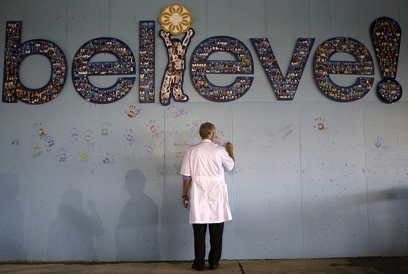 Children's Hospital at Erlanger Chief Medical Officer Dr. Alan Kohrt signs the wall during a Topping Out ceremony at the Children's Outpatient Center at Erlanger on Thursday, Nov. 9, 2017 in Chattanooga, Tenn. The Topping Out ceremony is a traditional builder's milestone, signifying that the final beam is put into place. The outpatient center is set to open in December 2018.