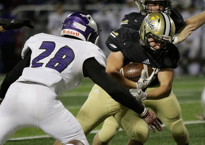 Calhoun's Zack Fuller carries around Monroe Area's Jaquaris Booker during the Yellow Jackets' second-round Georgia Class AAA football playoff game against the Purple Hurricanes at Calhoun High School last Friday.