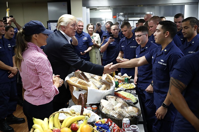 President Donald Trump, with first lady Melania Trump, greets and hands out sandwiches to members of the U.S. Coast Guard, at the Lake Worth Inlet Station, on Thanksgiving, Thursday, Nov. 23, 2017, in Riviera Beach, Fla. (AP Photo/Alex Brandon)
