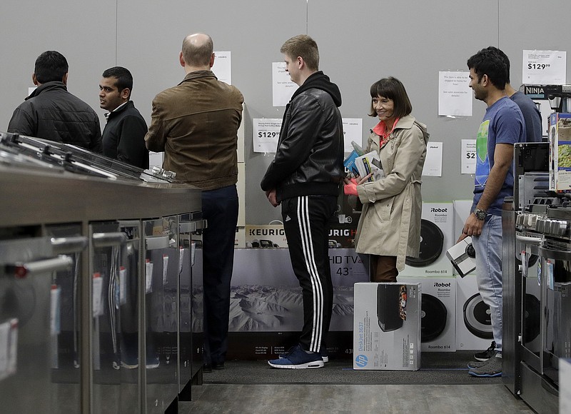 People line up to check out as they shop a Black Friday sale at a Best Buy store on Thanksgiving Day, Thursday, Nov. 23, 2017, in Overland Park, Kan. Shoppers are hitting the stores on Thanksgiving as retailers under pressure look for ways to poach shoppers from their rivals. (AP Photo/Charlie Riedel)