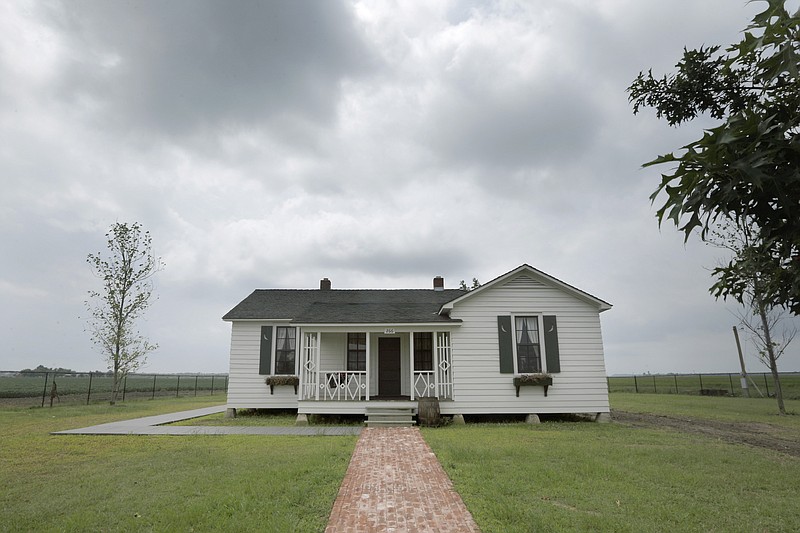 In this Friday, Aug. 8, 2014 file photo, rain clouds gather over the childhood home, dating to the mid 1930s, of singer Johnny Cash, in Dyess, Ark. The country music icon Cash's boyhood home is being considered as a nominee for inclusion on the National Register of Historic Places. The Arkansas Historic Preservation Program's review board is to meet Wednesday, Nov. 29, 2017, to consider 14 state properties for nomination to the list of the nation's historic places, including the Cash home that was built in 1934 in Dyess in northeastern Arkansas, about 30 miles northwest of Memphis, Tenn. (AP Photo/Danny Johnston, File)