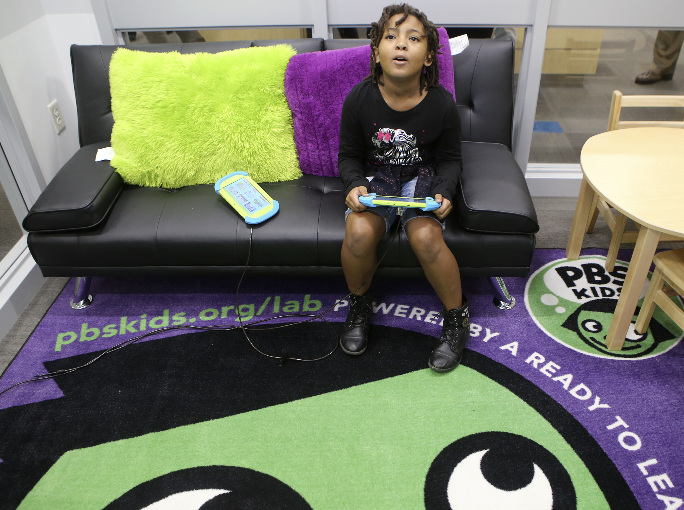 Nine-year-old Mikayla Sanders looks up at the television while checking out the PBS KIDS Learning Lounge at the Family Justice Center on Thursday, Nov. 9, 2017 in Chattanooga, Tenn. The Learning Lounge offers a fun area for children to use while in a waiting room.