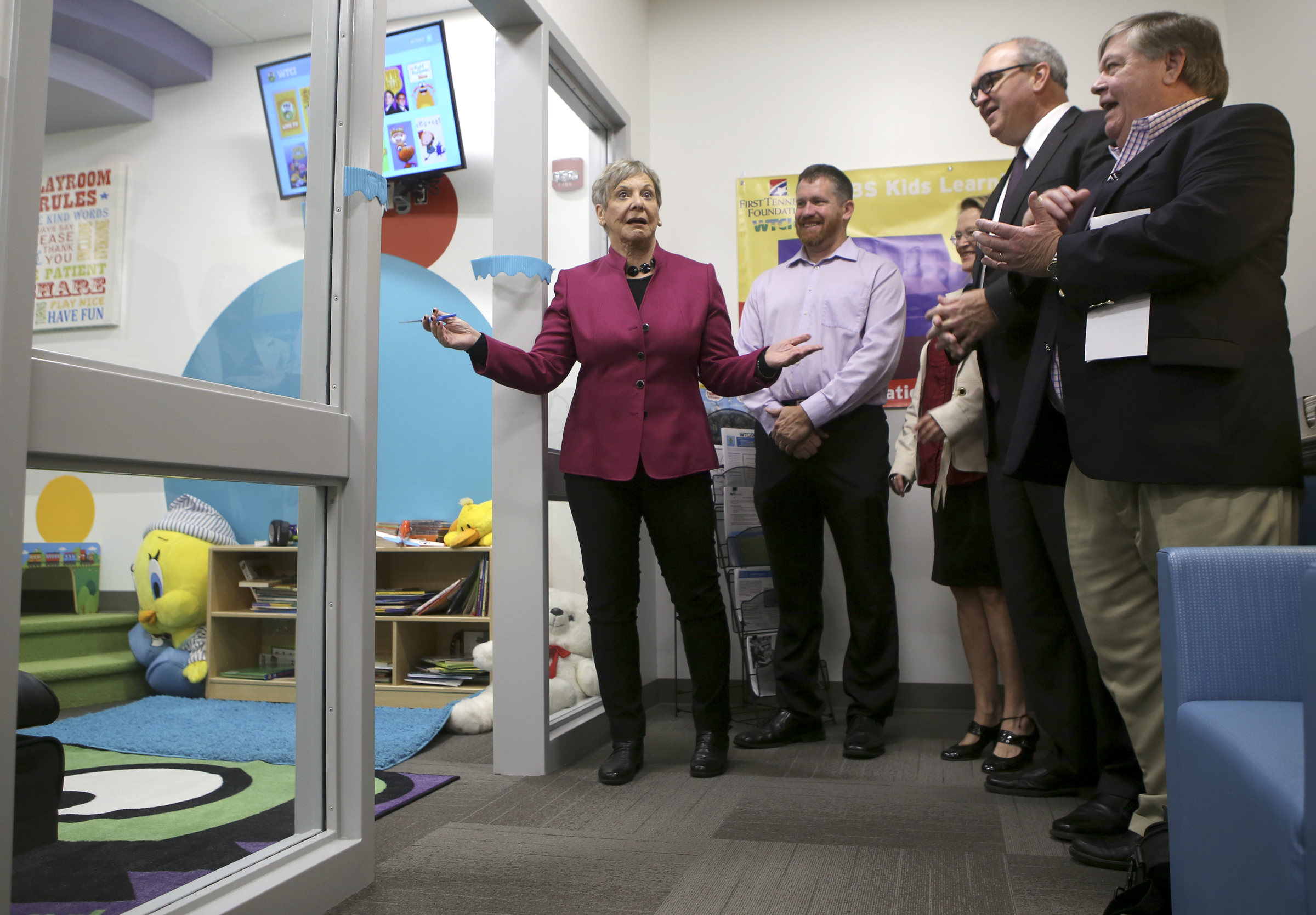 District 6 Councilwoman Carol Berz, left, reacts after cutting the ribbon for the PBS KIDS Learning Lounge at the Family Justice Center on Thursday, Nov. 9, 2017 in Chattanooga, Tenn. Joining Berz are, from left, Jason McKinney, Jennifer Crutchfield, Jeff Jackson and Richard Johnson. McKinney is the deputy administrator of Youth and Family Development. Crutchfield is the communications and community engagement director for Chattanooga's PBS channel, WTCI. Jackson is the market president for First Tennessee bank. Johnson is the vice president of development at WTCI. The Learning Lounge offers a fun area for children to use while in a waiting room.