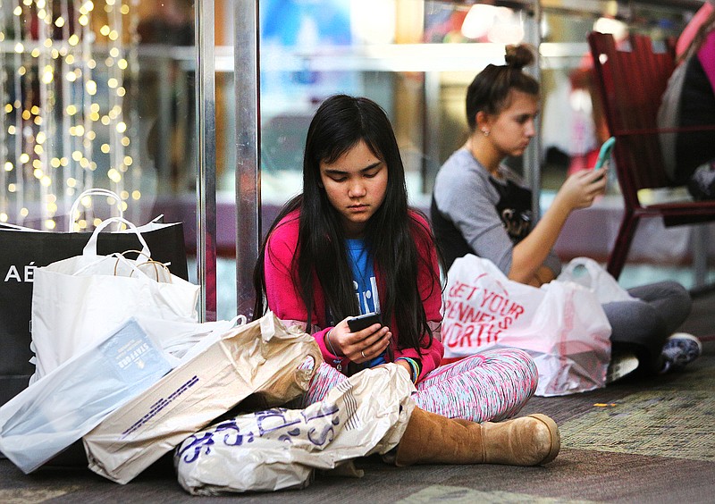 Zeianna Leonforte, 10, sits down with the fruits of her labor from Black Friday shopping at Hamilton Place Mall Friday, Nov. 24, 2017 in Chattanooga, Tenn. Zeianna got up at 5 a.m. to go shopping with her mom.