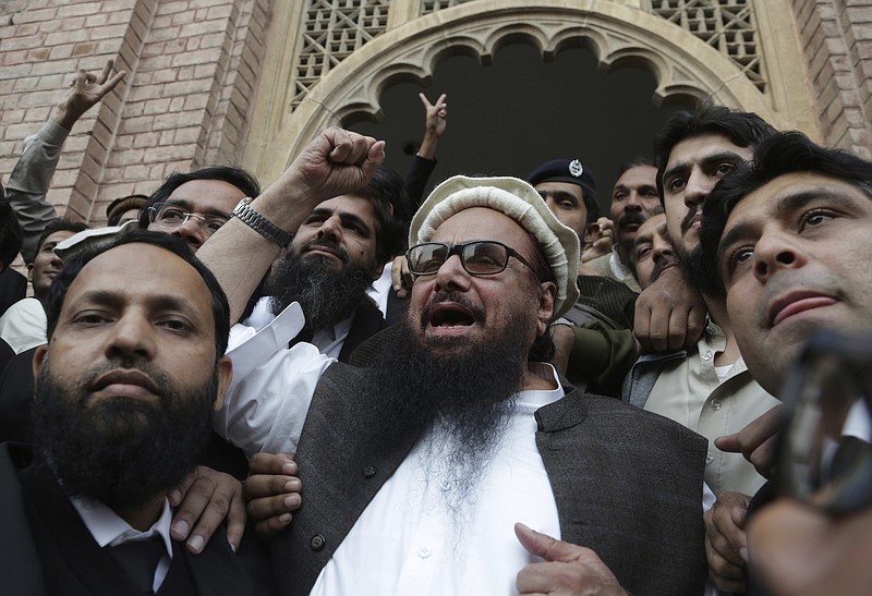 Hafiz Saeed, head of the Pakistani religious party, Jamaat-ud-Dawa, gestures outside a court in Lahore, Pakistan, Wednesday, Nov. 22, 2017. The court rejected the government's plea to extend for three months the house arrest of Saeed, the former leader of a banned militant group allegedly linked to 2008 Mumbai terrorist attack. (AP Photo/K.M. Chaudary)