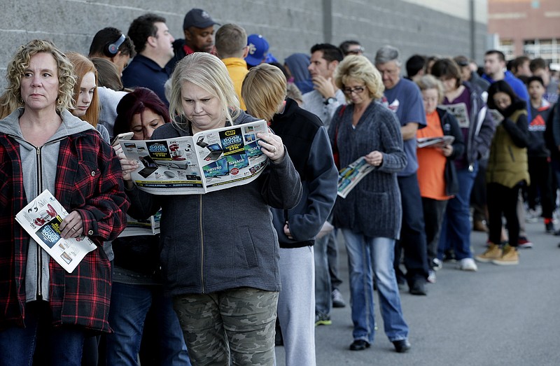 People wait in line for a Best Buy store to open for a Black Friday sale on Thanksgiving Day, Thursday, Nov. 23, 2017, in Overland Park, Kan. Shoppers are hitting the stores on Thanksgiving as retailers under pressure look for ways to poach shoppers from their rivals. (AP Photo/Charlie Riedel)