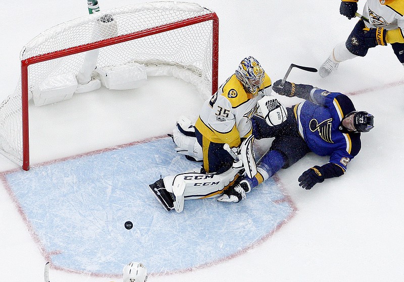 St. Louis Blues' Dmitrij Jaskin, of Russia,, right, slides into Nashville Predators goalie Pekka Rinne during the second period of an NHL hockey game Friday, Nov. 24, 2017, in St. Louis. (AP Photo/Jeff Roberson)