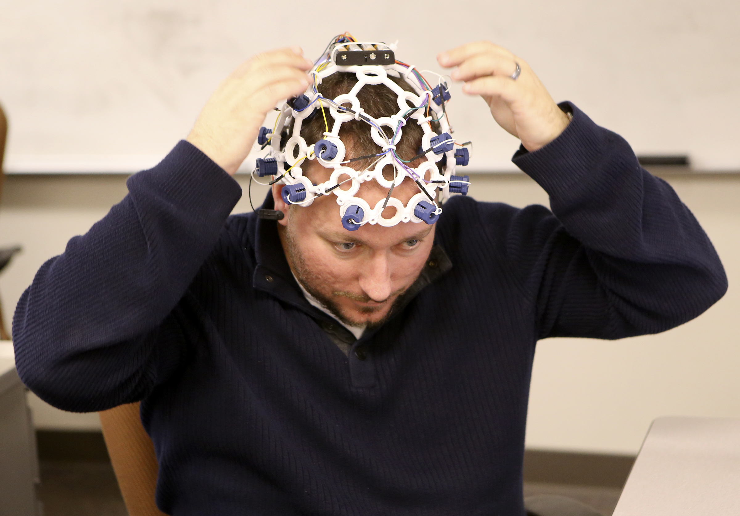 UTC senior Tony Ferguson, an electrical engineering major, puts the headset on to demonstrate the ability to control a drone with brainwaves in the SimCenter on the campus of the University of Tennessee at Chattanooga on Tuesday, Nov. 21, 2017 in Chattanooga, Tenn. Sixteen sensors, reading different parts of the brain, detect electrical impulses in the user to trigger commands for the drone.