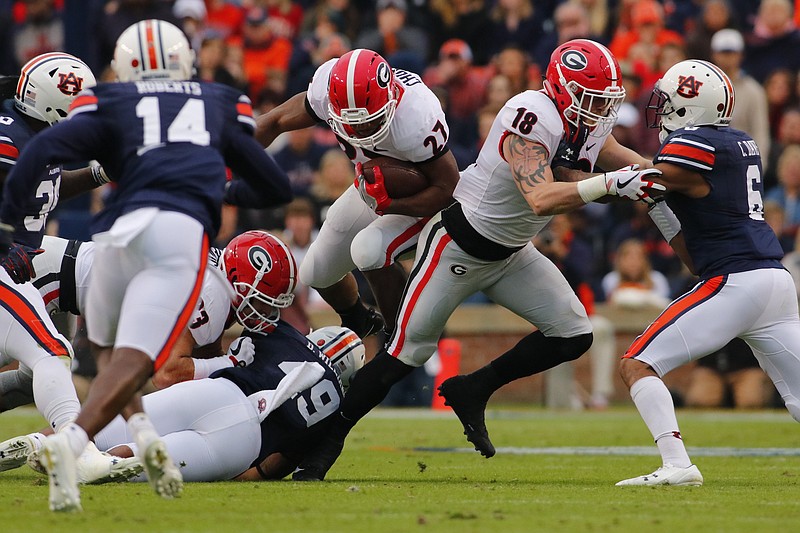 Georgia running back Nick Chubb, center, tries to find running room during a 40-17 loss at Auburn on Nov. 11. The Bulldogs and Tigers will vie for the 122nd time this Saturday but for a first occasion in the Southeastern Conference championship game.