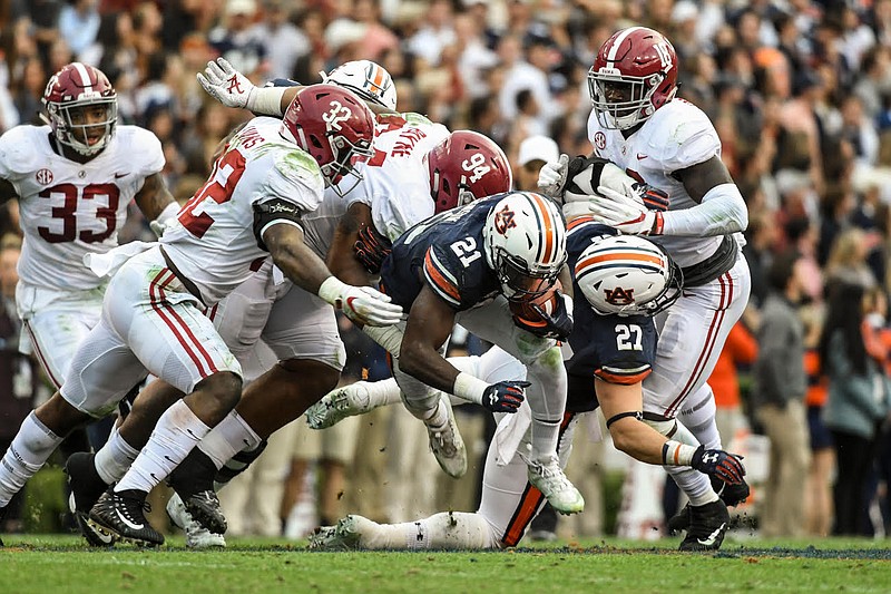 Alabama defenders Rashaan Evans (32), Da'Ron Payne (94) and Dylan Moses (18) converge on Auburn running back Kerryon Johnson during Saturday's 26-14 win by the Tigers.