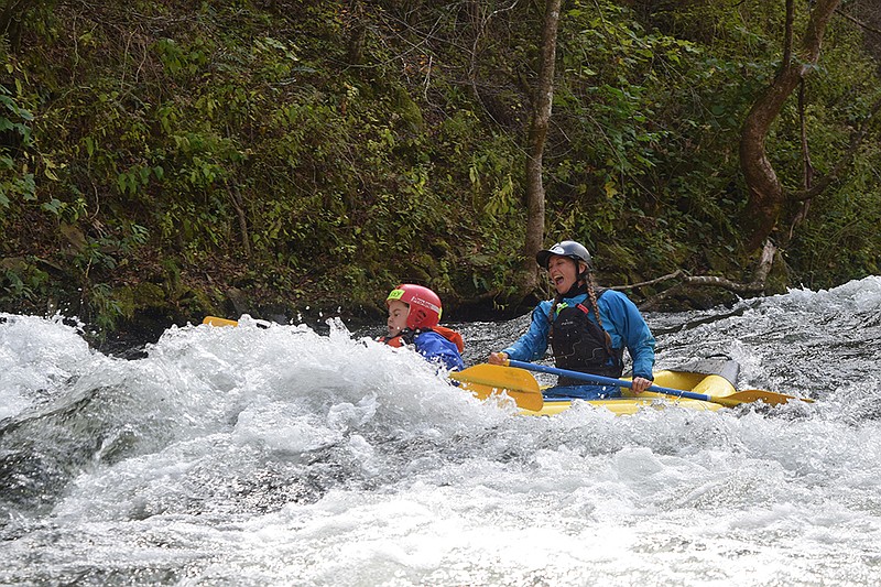 In an inflatable duckie, whitewater volunteer Holly Reppert guides one child through a splashy Class II rapid. 