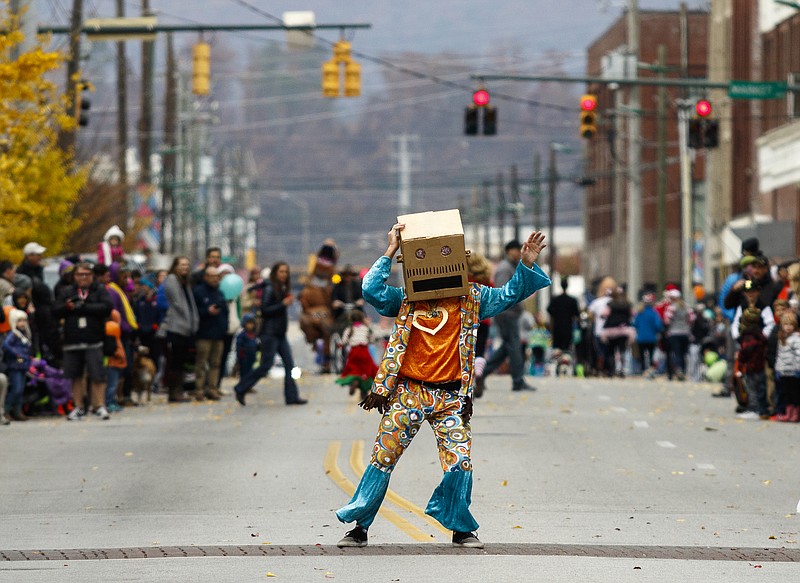 Lola Therrien waves to a parade participant dressed as a dinosaur during last year's MainX24.