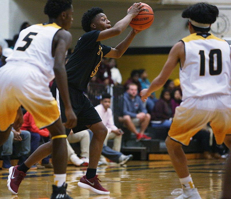 Tyner's Michael Little (5) looks to pass the ball while being guarded by Hixson's Maurice Carter (5) and Lucas Alemeda (10) during the Hixson vs. Tyner boys basketball game Tuesday, Nov. 28, 2017 at Hixson High School in Hixson, Tenn. 