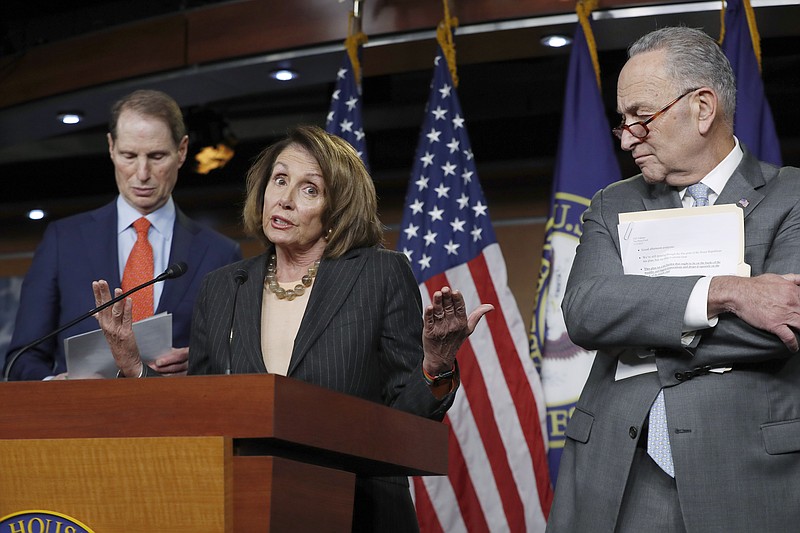 FILE - In this Nov. 2, 2017 file photo, House Minority Leader Nancy Pelosi, D-Calif., flanked by Sen. Ron Wyden, D-Ore., the ranking member of the Senate Finance Committee, left, and Senate Minority Leader Chuck Schumer, D-N.Y., holds a news conference on Capitol Hill to respond to the Republican tax reform plan in Washington.