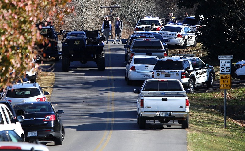 A large contingent of law enforcement vehicles is seen along Royal Oaks Drive as they negotiate a hostage situation on Tuesday, Nov. 28, 2017 in Cleveland, Tenn. 