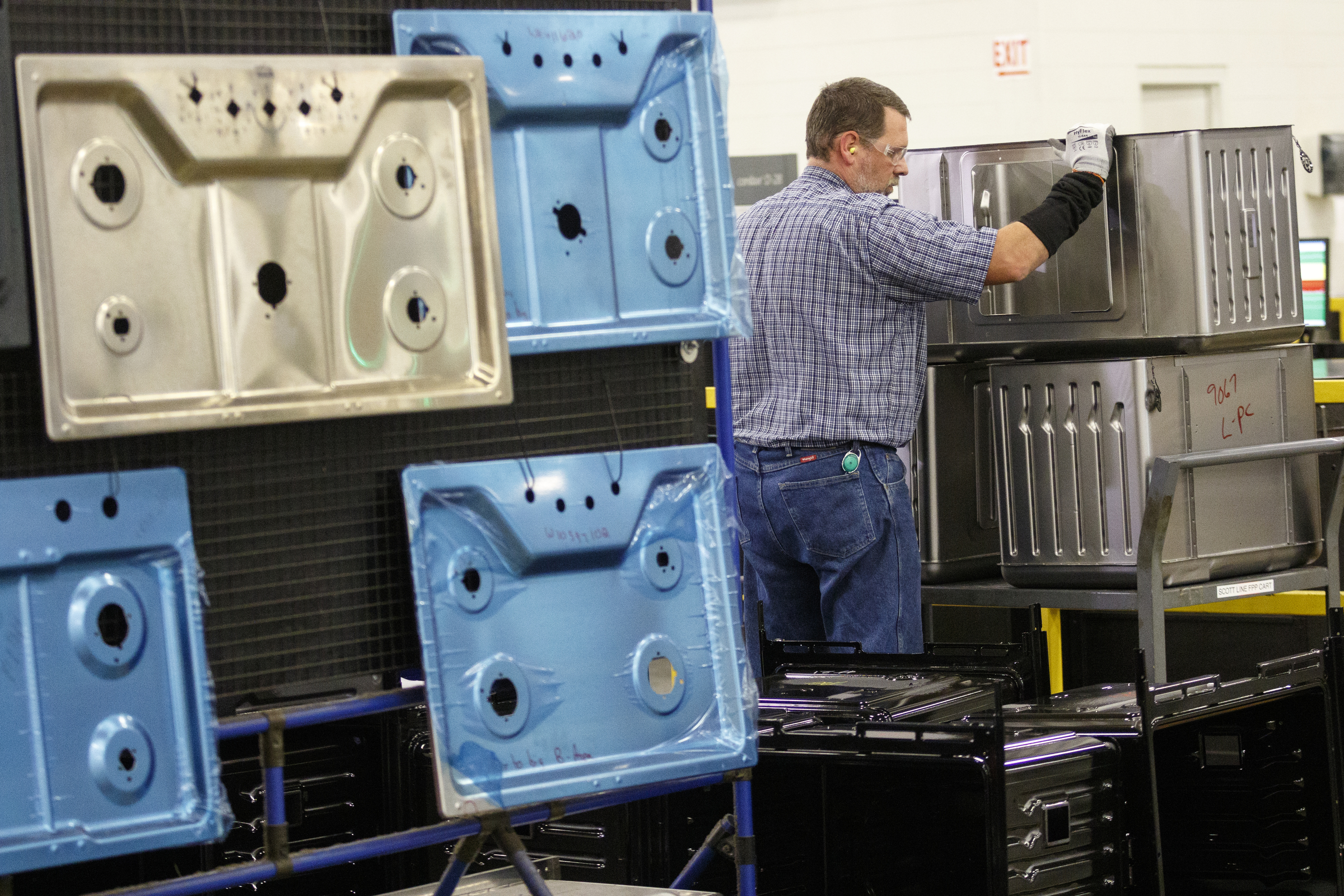 A worker moves appliance parts from a press at the Whirlpool manufacturing plant on Thursday, Oct. 6, 2016, in Cleveland, Tenn. The plant gave tours of its facility for National Manufacturing Week.