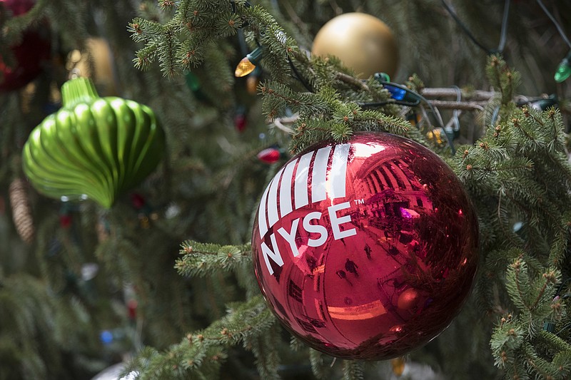 The New York Stock Exchange is seen reflected on an ornament hanging on a Christmas tree outside the exchange, Thursday, Nov. 30, 2017, in New York. Stocks powered to new highs on Wall Street, giving the Dow Jones industrials their biggest gain since March and putting them past 24,000 for the first time. (AP Photo/Mary Altaffer)