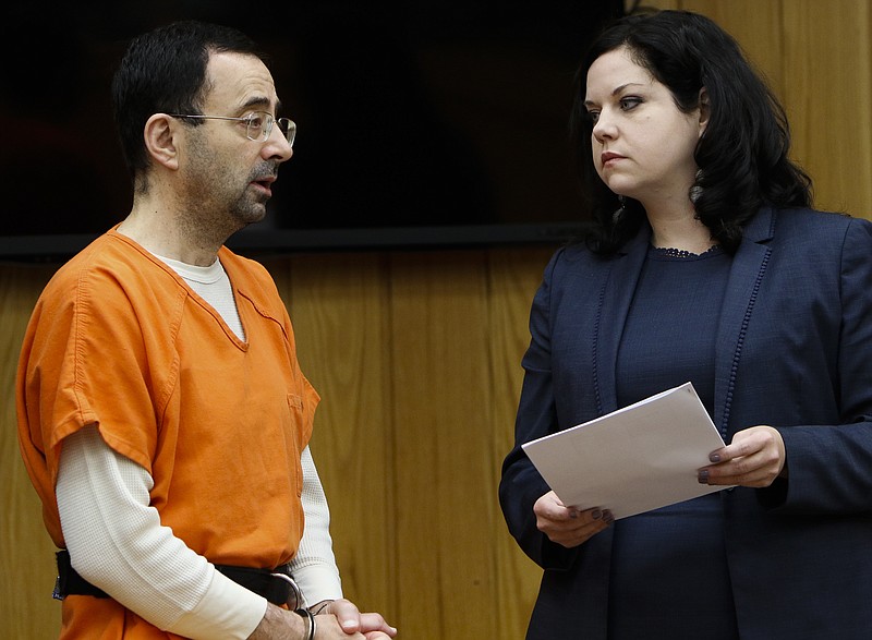 Former sports doctor Larry Nassar, left, stands with his attorney Shannon Smith as he pleads guilty to three counts of first-degree criminal sexual conduct Wednesday, Nov. 29, 2017, in Judge Janice Cunningham's courtroom in Eaton County, Mich. (Matthew Dae /Lansing State Journal via AP)