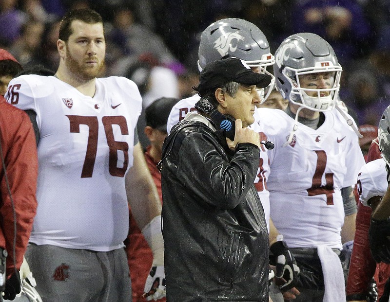 Washington State head coach Mike Leach, center, stands on the sideline next to quarterback Luke Falk (4) late in the second half of an NCAA college football game against Washington, Saturday, Nov. 25, 2017, in Seattle. Washington won 41-14. (AP Photo/Ted S. Warren)