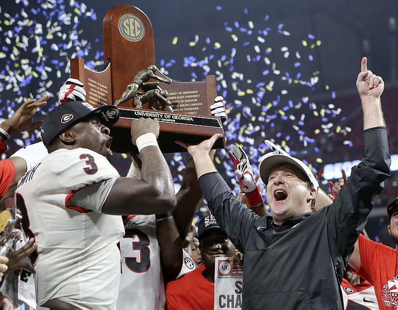 Georgia linebacker Roquan Smith (3) and head coach Kirby Smart raise the trophy after winning the Southeastern Conference championship 28-7 over Auburn at Mercedes-Benz Stadium on Saturday, Dec. 2, 2017 in Atlanta, Ga.