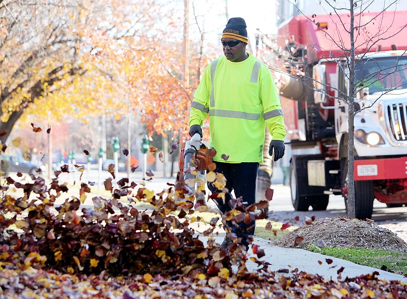 Patrick Postell, a crew worker with the Chattanooga Department of Public Works, clears the sidewalk along Vine Street near Georgia Avenue Sunday, Dec. 3, 2017 in downtown Chattanooga. A Public Works crew was working its way around the downtown and North Shore areas clearing the sidewalks of leaves and other debris.