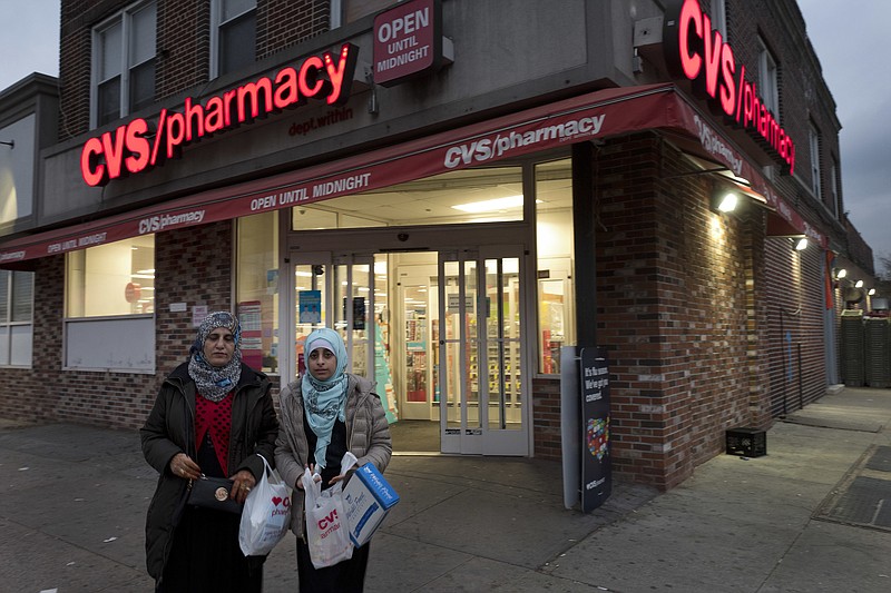 
              Customers leave a CVS Pharmacy, Sunday, Dec. 3, 2017 in the Brooklyn borough of New York. CVS will buy insurance giant Aetna in a roughly $69 billion deal that will help the drugstore chain reach deeper into customer health care and protect a key client, a person with knowledge of the matter said Sunday. (AP Photo/Mark Lennihan)
            