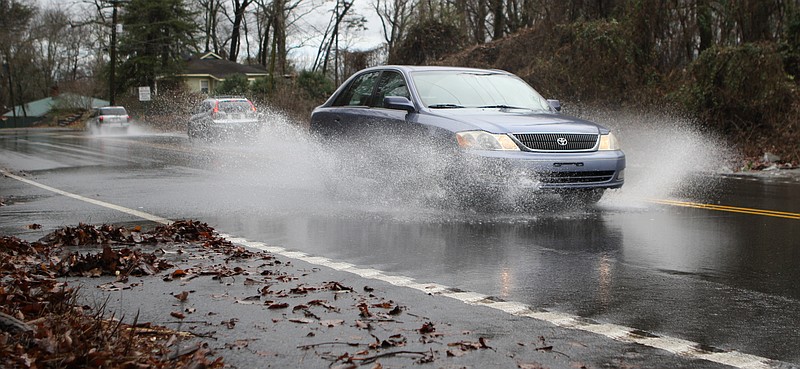 In this Dec. 22, 2013, staff file photo, vehicles drive through rain runoff on Signal Mountain Boulevard on Sunday.