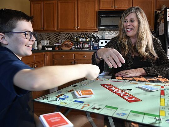 Jacqueline Perrine plays Monopoly with her grandson, Ryder, on Nov. 20 in Spring Hill, Tenn. Perrine became an anti-drug, pro-recovery advocate after her 30-year-old son died of a heroin overdose two years ago. (Photo by Larry Mccormack/The Tennessean)