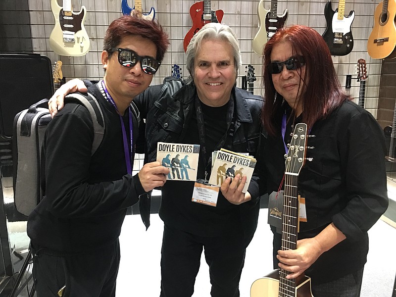 Doyle Dykes is shown with a father and son he met in Shanghai, China, early this year. Both said they are big fans and play his music all of the time. Dykes will play Tuesday night at Songbirds.