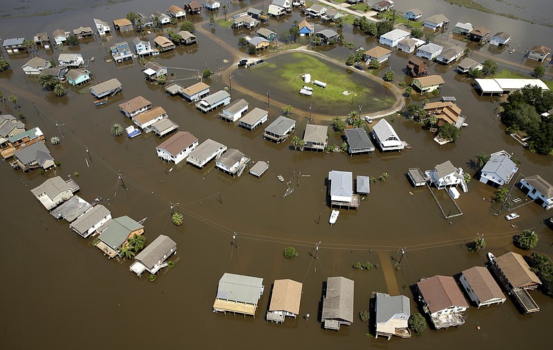 In this Sept. 1, 2017, file photo, homes are surrounded by flood water in the aftermath of Hurricane Harvey near Galveston, Texas. More than three months after Hurricane Harvey walloped Texas, many affected residents say they're still not getting help they need and President Donald Trump is getting low marks for his handling of the disaster, according to a Kaiser Family Foundation/Episcopal Health Foundation survey released Tuesday, Dec. 4. (AP Photo/Charlie Riedel, File)