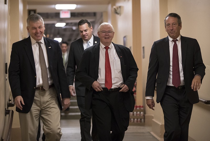 In this Dec. 5, 2017, photo, House Republicans, from left, Rep. Rob Woodall, R-Ga., Rep. Richard Hudson, R-N.C., Rep. Joe Barton, R-Texas, and Rep. Mark Sanford, R-S.C., arrive for a closed-door strategy session on Capitol Hill in Washington. Sounding a discordant note among the positive talk on the tax bill, a number of Republicans are delivering a blunt assessment, casting the bill as a boost to big corporations and the wealthy instead of the middle class. "Fundamentally if you look at the bulk of the bill, two-thirds of it, it's tied on the business side,” Sanford said Tuesday as leaders in the House and Senate hailed their respective measures as an advantage for working Americans. (AP Photo/J. Scott Applewhite)