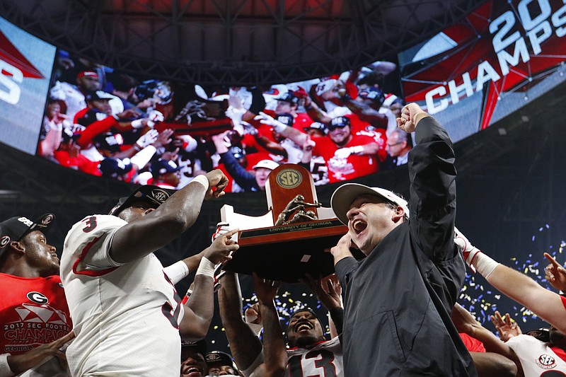 Georgia inside linebacker Roquan Smith (3) and coach Kirby Smart celebrate last Saturday's win over Auburn in the SEC title game. On Wednesday, Smith was named defensive MVP of the league, while Smart was named the conference's coach of the year.