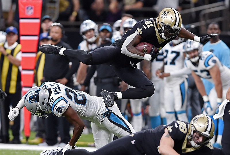 New Orleans Saints running back Alvin Kamara leaps over Carolina Panthers cornerback Daryl Worley during their NFC South matchup this past Sunday in New Orleans. The Saints won 31-21 to take sole possession of first place in the division, and they visit the Atlanta Falcons tonight.
