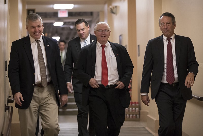 In this Dec. 5, 2017, photo, House Republicans, from left, Rep. Rob Woodall, R-Ga., Rep. Richard Hudson, R-N.C., Rep. Joe Barton, R-Texas, and Rep. Mark Sanford, R-S.C., arrive for a closed-door strategy session on Capitol Hill in Washington. 