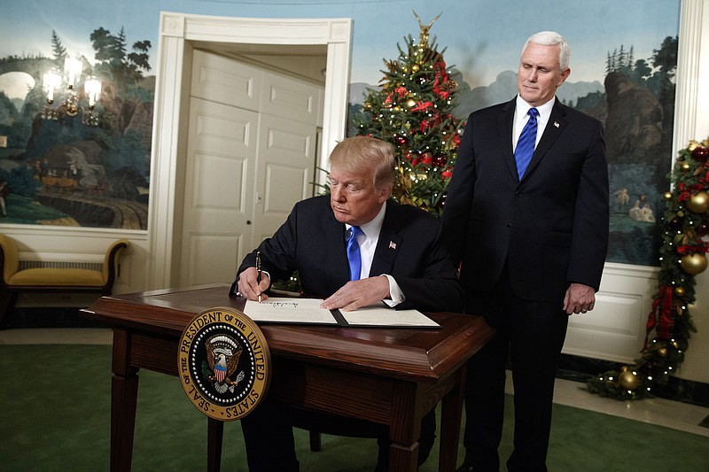Vice President Mike Pence looks on as President Donald Trump signs a proclamation to officially recognize Jerusalem as the capital of Israel, in the Diplomatic Reception Room of the White House, Wednesday, Dec. 6, 2017, in Washington. (AP Photo/Evan Vucci)