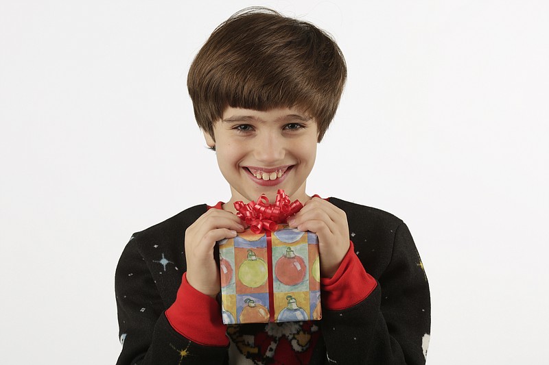 9-year-old CSLA student Ben Alverson poses with his winning wrapping paper design in the Times Free Press studio on Tuesday, Dec. 5, 2017, in Chattanooga, Tenn.