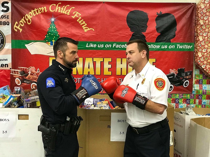 Chattanooga Police Chief David Roddy, left, and Fire Chief Phil Hyman stage a mock match for tonight's Guns and Hoses boxing event at the Chattanooga Convention Center. They are in front of a donation station for the Forgotten Child Fund, which will benefit along with YCAP.