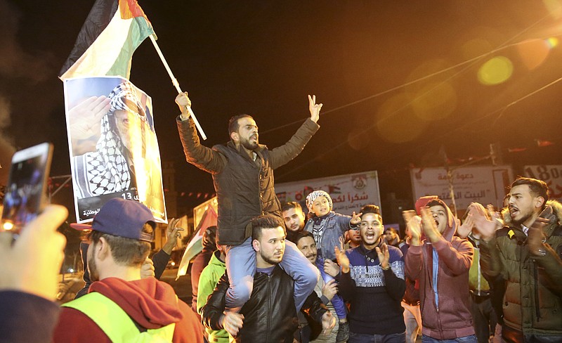 Palestinian protestors chant slogans as they wave their national flags and pictures of late Palestinian president Yasser Arafat during a protest at the main Square in Gaza City, Wednesday, Dec. 6, 2017. Defying worldwide warnings, U.S. President Donald Trump on Wednesday broke with decades of U.S. and international policy by recognizing Jerusalem as Israel's capital.(AP Photo/Adel Hana)